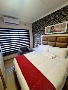 um quarto com uma cama grande e um cobertor vermelho em 36 frere road shelly beach , margate em Margate