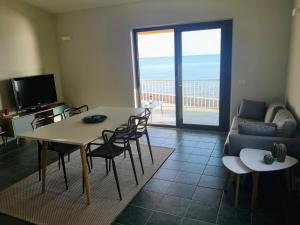 a living room with a table and chairs and a couch at casa con terrazza fronte mare in Santa Lucia