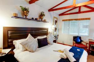 a bedroom with a large white bed with a wooden headboard at Strand Guesthouse in Strand