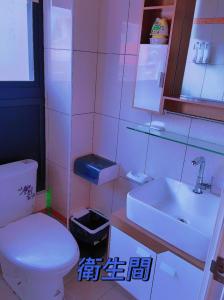 ein Badezimmer mit einem weißen WC und einem Waschbecken in der Unterkunft 親愛的民宿 in Jinning