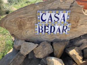 ein Schild, auf dem steht: Casa bedar sitzt auf einem Logbuch in der Unterkunft Casa Bédar in Bédar