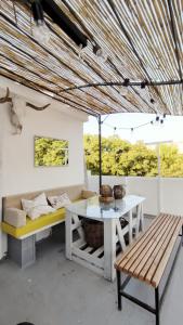 a living room with a table and a bench at Ático Plaza España in Jerez de la Frontera