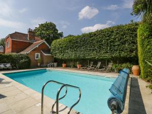 een zwembad met een ligstoel naast een huis bij Downton Lodge in Lymington