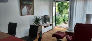 a living room with a television and a table and chairs at Ferienwohnung an der Gustavsburg in Homburg