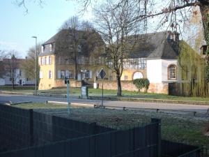 a house with a fence in front of a street at Ferienwohnung an der Gustavsburg in Homburg