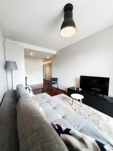 a person laying on a couch in a living room at Santa Luzia's Pearl II - One Bedroom Apartment in Funchal