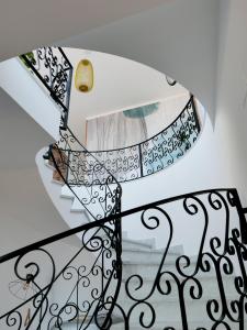 a spiral staircase with a wrought iron railing at Al 33 Giri in Cefalù
