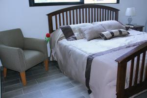 1 dormitorio con 1 cama con silla y silla en Amazing Mexican Airport Inn, en Cancún