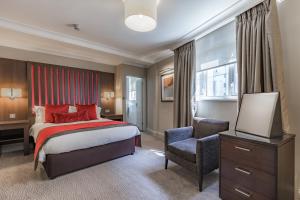 a bedroom with a bed and a dresser at Grand Jersey Hotel and Spa in Saint Helier Jersey