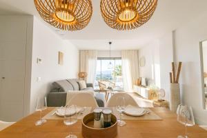 - une salle à manger et un salon avec une table et des chaises dans l'établissement CASA ROMAN new apartment at Baviera Golf, à Malaga