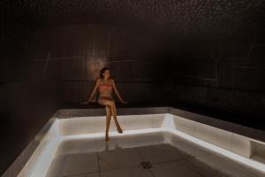 a woman is sitting in a bath tub at Rivage Hôtel & Spa Annecy in Annecy