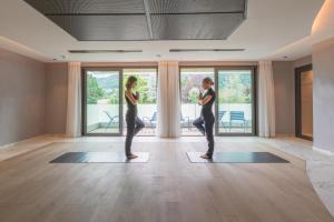 a woman doing yoga in a room with windows at Rivage Hôtel & Spa Annecy in Annecy