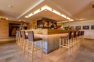 a bar in a restaurant with stools around it at Hotel Fischer in Bressanone