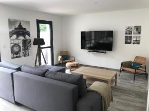 a living room with a couch and a table at La Foret d'Armotte in Saint-Augustin