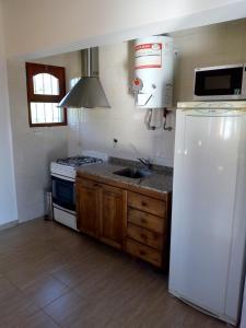 a kitchen with a white refrigerator and a sink at Cabaña Casablanca in La Granja