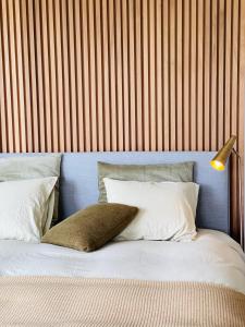 a bed with white pillows and a lamp on it at Lit de Clémot in Merelbeke