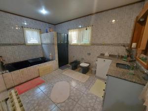 a tiled bathroom with a sink and a toilet at Sítio Dos Amigos in Canela +31 photos