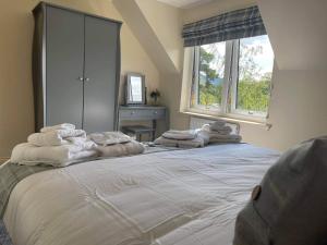 una camera da letto con un grande letto con asciugamani bianchi di An Outdoor Enthusiasts Piece of Heaven a Gairlochy