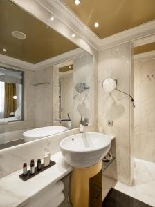 a white bathroom with a sink and a tub at The Excelsior - Small Luxury Hotels of the World in Thessaloniki