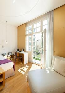 a bedroom with a bed and a large window at The Excelsior - Small Luxury Hotels of the World in Thessaloniki