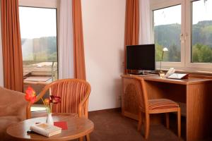 um quarto de hotel com uma secretária com um computador e uma janela em Boarding House Remstal em Weitmars
