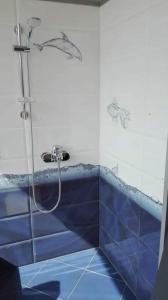 ein Bad mit einer Dusche und blauen Fliesen in der Unterkunft Апартамент в най-хубавия квартал на Варна in Warna