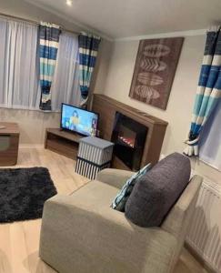 a living room with a couch and a television at 8 Berth,Waterside Leisure,Ingoldmells in Ingoldmells