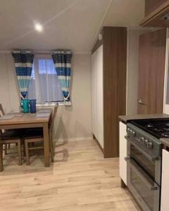 a kitchen with a table and a stove top oven at 8 Berth,Waterside Leisure,Ingoldmells in Ingoldmells