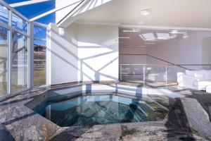 uma piscina numa casa com piso de vidro em Pousada Dreams em Campos de Jordão