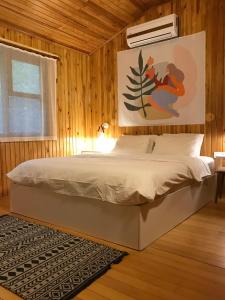 ein Schlafzimmer mit einem Bett in einer Holzwand in der Unterkunft Kibala Hotel in Cıralı