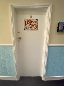 a white door with a sign on it at The Lobster Shack in Criccieth