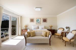 um quarto com uma cama e um sofá em Pousada Dreams em Campos de Jordão