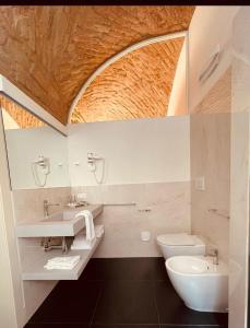 a bathroom with a sink and a toilet and a mirror at Palazzo Borgocolonne Apartments in Parma