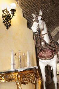 een standbeeld van een wit paard naast een tafel bij Locanda Dei Baroni in Vasto