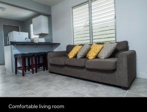 un soggiorno con divano e una cucina di Tropical Getaway ad Aguadilla
