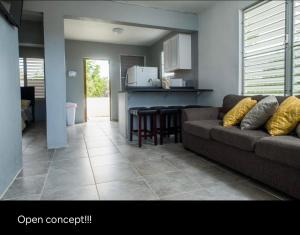 a living room with a couch and a kitchen at Tropical Getaway in Aguadilla
