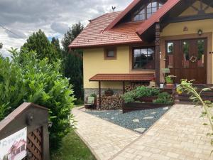 a house with a brick walkway in front of it at Velemi Vendégház in Velem