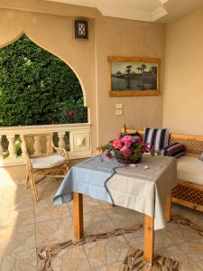 - un salon avec une table et des fleurs dans l'établissement House of Hathor, à Louxor