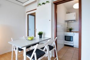 una cucina e una sala da pranzo con tavolo e sedie bianchi di Kleine Auszeit Niendorf a Niendorf