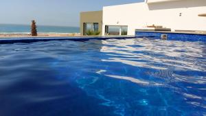 een zwembad met blauw water voor een huis bij 2 bungalows avec vue sur mer et piscine PARTAGEE in Oualidia