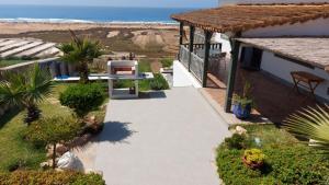 un patio con vistas a la playa y a una casa en Maison de plage avec piscine et vue sur mer en Oualidia