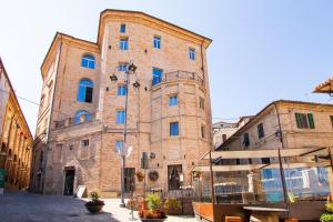 a large brick building with blue windows on a street at MA Hotel in Corinaldo