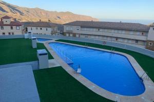 una vista aérea de una gran piscina azul en Apartamento nuevo con piscina en la envía golf aguadulce Almería, en La Envía