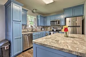a blue kitchen with a counter with a vase of flowers at Relaxing Texas Getaway, 1 Mile to Boat Ramp! in Jefferson