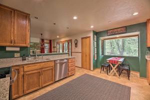 a kitchen with green walls and wooden cabinets and a table at Deck and Yard Family-Friendly Pinetop Retreat in Indian Pine