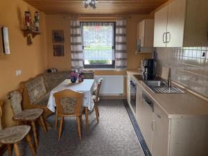 a small kitchen with a table and chairs in a kitchen at Ferienhaus an der Fichtelbergbahn in Cranzahl