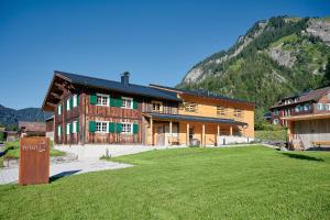 a large building with a grass field in front of it at Wald 12 Ferienhaus in Wald am Arlberg