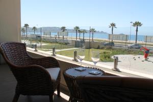- une table avec deux verres à vin et une vue sur la plage dans l'établissement Departamento Av del Mar Coquimbo Disegni 03, à Coquimbo