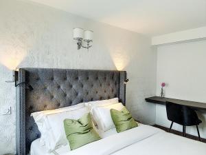 a bedroom with a large bed with green pillows at MOYÏ in Basse-Goulaine