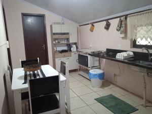 a kitchen with a sink and a table and a counter at Casa Refúgio e Aconchego in Igrejinha
